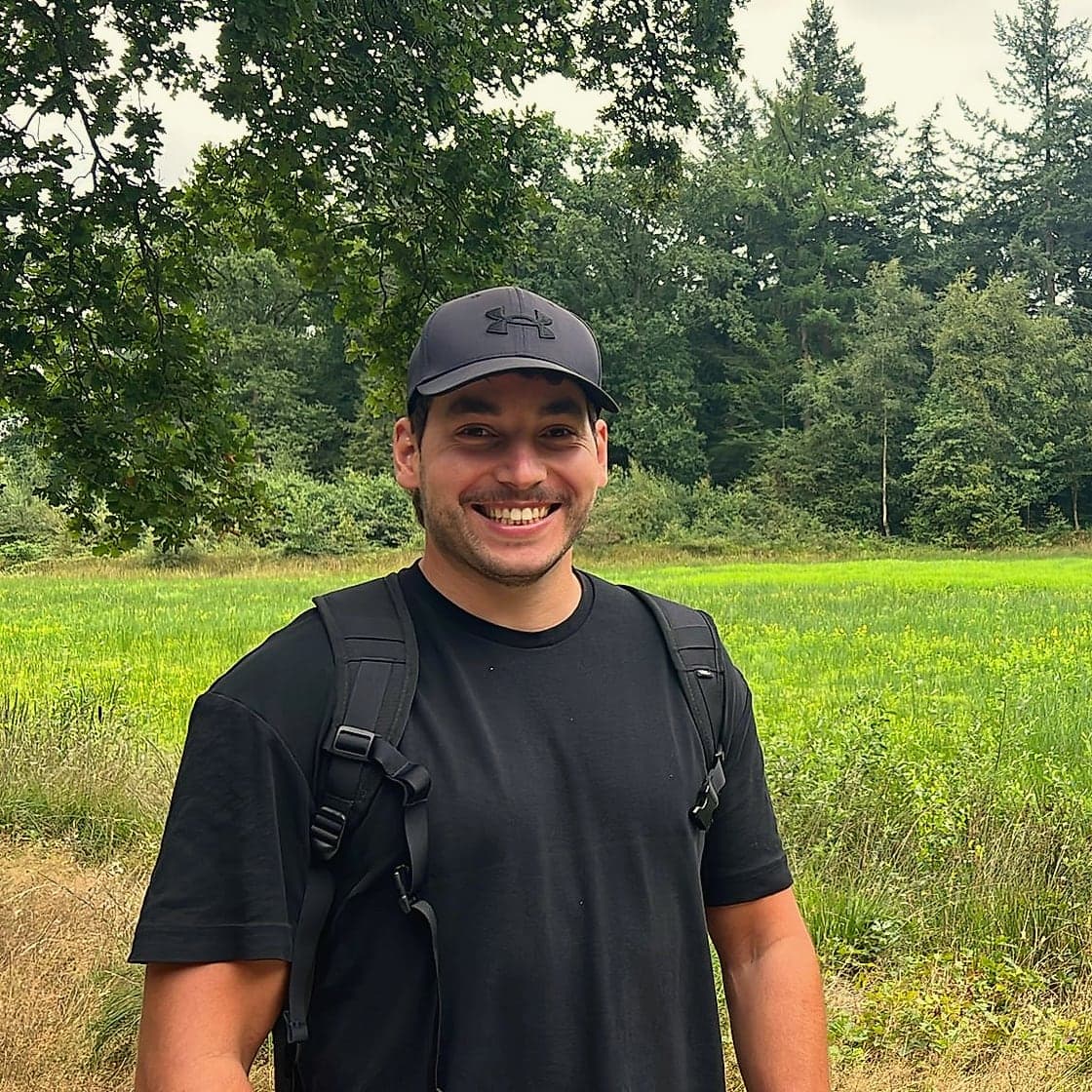 Coen Letteboer, lachend, in een grasveld met bomen op de achtergrond